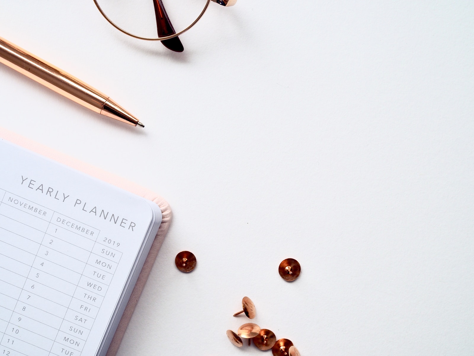 Photo par Jess Bailey buttons and thumbtacks beside planner book on table